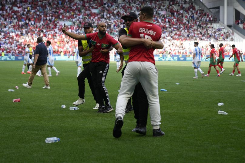 Das Fußballspiel zwischen Argentinien und Marokko wurde für fast zwei Stunden unterbrochen, da die marokkanischen Fans den Platz stürmten.