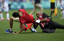 Uno steward acciuffa un invasore di campo durante la partita tra Argentina e Marocco alle Olimpiadi estive 2024, allo stadio di Saint-Etienne, 24 luglio 2024