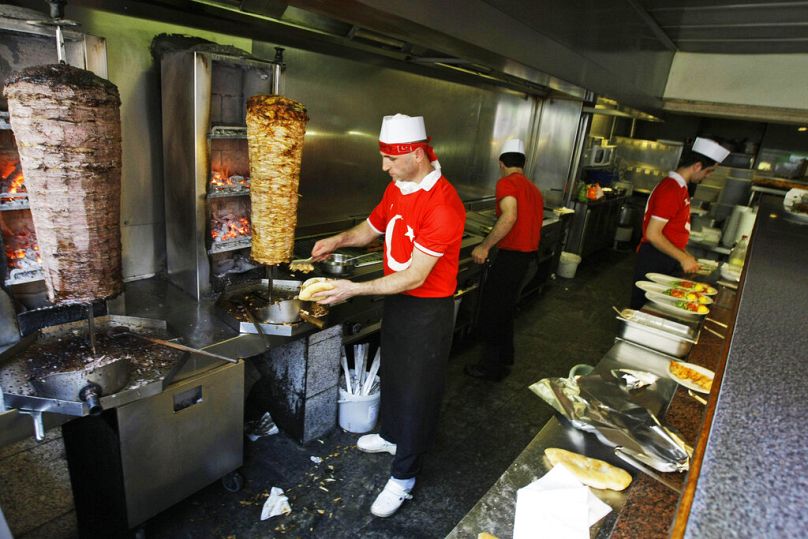 Un cuisinier turc découpe de la viande à un stand de nourriture locale dans un quartier mixte croate et turc de Vienne, Autriche, vendredi 20 juin 2008.