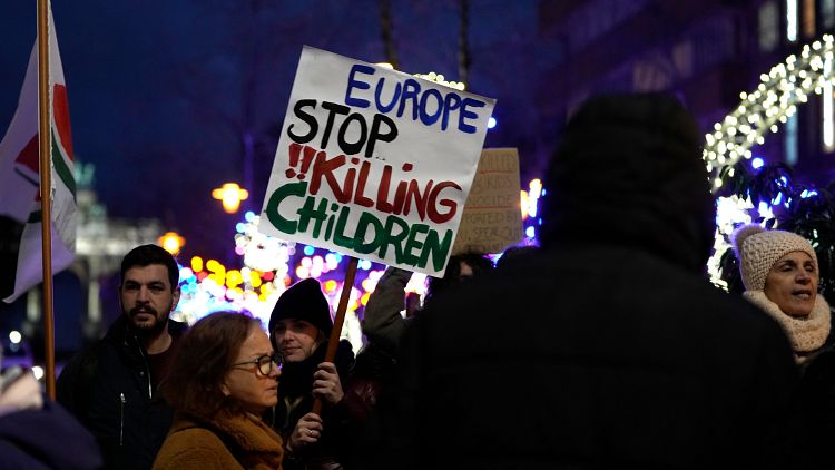 A protestor holds a sign during a demonstration calling for a ceasefire in Gaza outside an EU summit in Brussels.