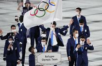 Юсра Мардини и Тачловини Габриесос из олимпийской команды беженцев несут олимпийский флаг во время церемонии открытия на Олимпийском стадионе на летних Олимпийских играх 2020 года.