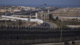 فلسطينيون نزحوا بسبب القصف الإسرائيلي لقطاع غزة يسيرون بجوار الحدود مع مصر، في رفح، جنوب غزة، الأحد، 14 يناير، 2024. 