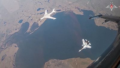 A H-6K long-range bomber of the Chinese air force, left, is seen escorted by a Su-30 fighter of the Russian air force during a joint Russia-China air patrol, 25 July 2024