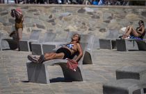 People sunbathe on a promenade in Barcelona, Spain, Wednesday, July 24, 2024. 