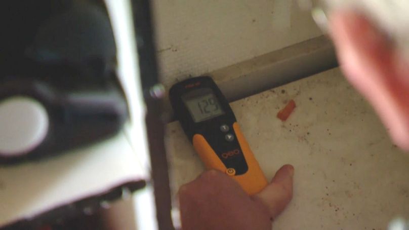 An expert measures for mould in a Danish house.