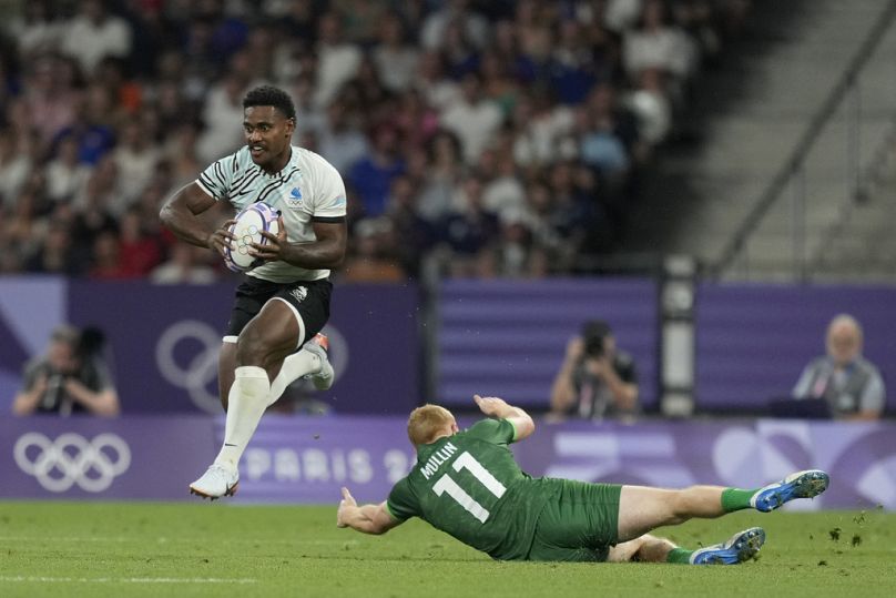 Fiji's Kaminieli Rasaku, left, gets past Ireland's Gavin Mullin during the men's quarterfinal match Rugby Sevens between Fiji and Ireland 