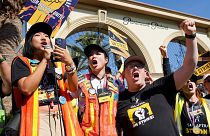 SAG-AFTRA captains Iris Liu, left, and Miki Yamashita, center, and SAG-AFTRA chief negotiator Duncan Crabtree-Ireland lead a cheer for striking actors in 2023