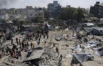 Filistinliler Gazze Şeridi'nin güneyindeki Han Yunus'ta İsrail bombardımanının ardından bölgedeki hasarı inceliyor, 13 Temmuz 2024. 