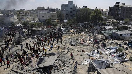 Filistinliler Gazze Şeridi'nin güneyindeki Han Yunus'ta İsrail bombardımanının ardından bölgedeki hasarı inceliyor, 13 Temmuz 2024. 