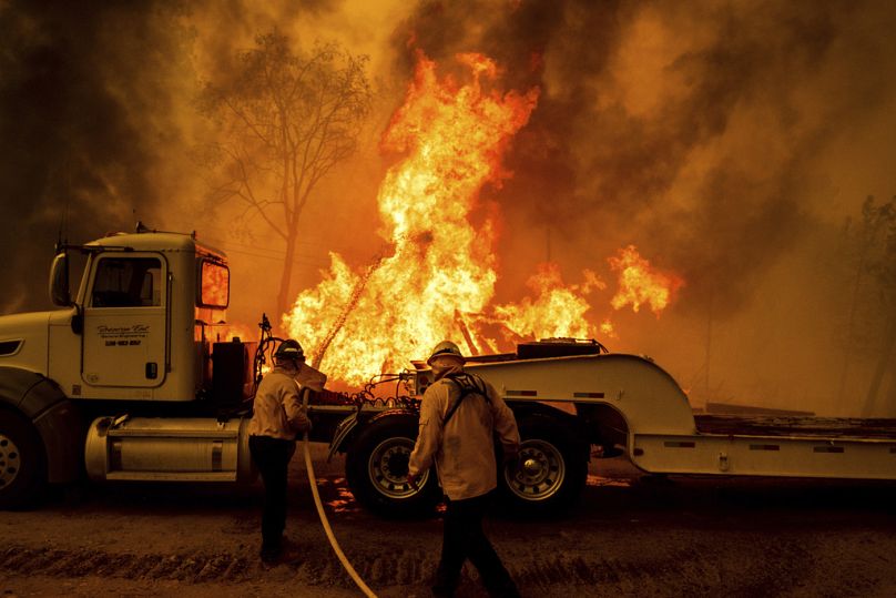 Firefighters spray water as the Park Fire tears though the Cohasset community in Butte County.