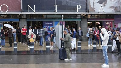 Travelers wait outside the Gare de Montparnasse train station