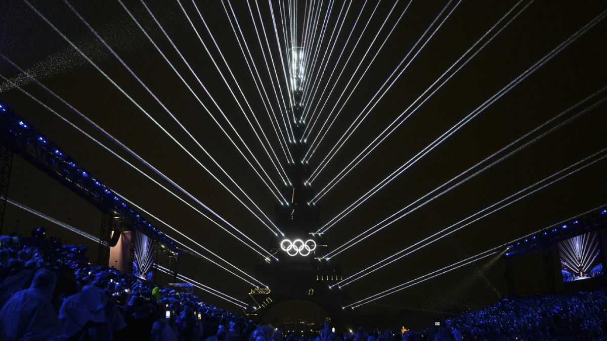 The Olympic rings are illuminated as lights emanate from the Eiffel Tower at the Trocadero during the opening ceremony for the 2024 Summer Olympics in Paris, France