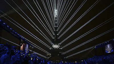 The Olympic rings are illuminated as lights emanate from the Eiffel Tower at the Trocadero during the opening ceremony for the 2024 Summer Olympics in Paris, France