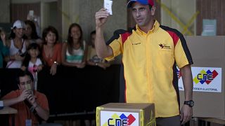 هنريكي كابريليس، حاكم ولاية ميراندا والمرشح الرئاسي السابق يظهر بطاقة اقتراعه أثناء إدلائه بصوته خلال الانتخابات البلدية في كاراكاس، فنزويلا، الأحد 8 ديسمبر/كانون الأول 2013.