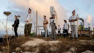 مستوطنون يهود متنطرفون يصلون على تلة احتلت لإنشاء بؤرة استيطانية بالضفة الغربية المحتلة
