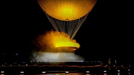Teddy Riner e Marie-Jose Perec osservano l'innalzamento del calderone in un pallone aerostatico a Parigi, in Francia, durante la cerimonia di apertura delle Olimpiadi estive del 2024, venerdì 26 luglio 2024.