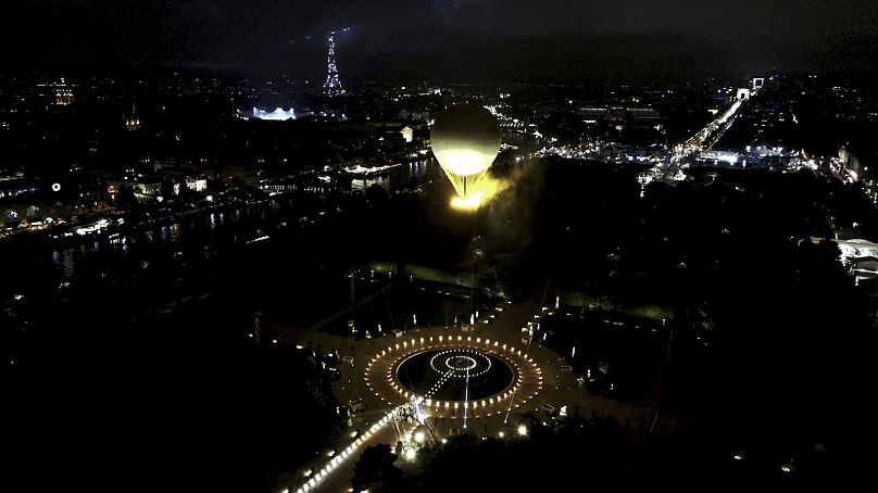 Die Schale mit dem brennenden olympischen Feuer hebt an einem Ballon befestigt während der Eröffnungsfeier der Olympischen Sommerspiele 2024 vom Boden ab. Paris, 26. Juli 2024