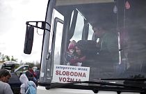 Frau mit Kind steigt in Berkasovo (Serbien) aus einem Bus, der sie an die serbisch-kroatische Grenze gebracht hat, 27. September 2015.