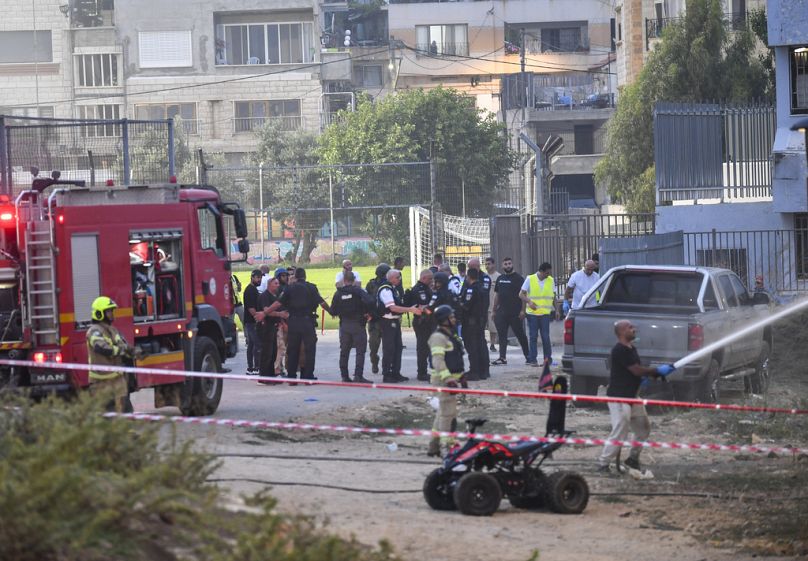 Agentes de policía y bomberos israelíes trabajan en el lugar de un ataque en Majdal Shams, en los Altos del Golán controlados por Israel, sábado 27 de julio de 2024