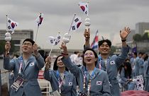 Güney Koreli sporcular Seine Nehri'nden geçerken ülkelerinin bayraklarını dalgalandırıyor, 26 Temmuz 2024