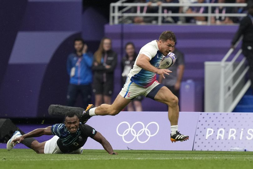 Antoine Dupont of France races clear of Fiji's Waisea Nacuqu to score a try during the men's gold medal Rugby Sevens match between France and Fiji at the 2024 Summer Olympics