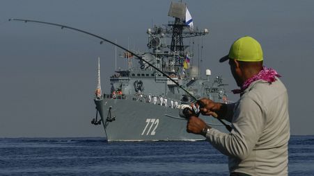 Ein Fischer wickelt seine Angelrute auf, als das Patrouillenboot "Neustraschimy" zu einem "Arbeitsbesuch" in Havanna einläuft, 27. Juli 2024