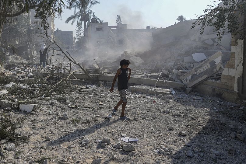 A Palestinian boy walks past the rubble of a school destroyed in an Israeli airstrike on Deir al-Balah, July 27, 2024