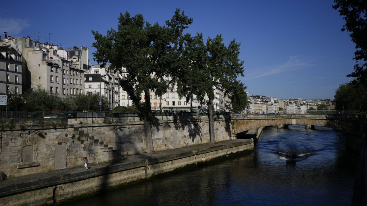 A man walks along the Seine river at the 2024 Summer Olympics, Sunday, July 28, 2024, in Paris, France.