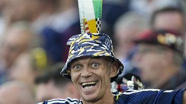 A Scotland fan balances a beer cup on his head before a Group A match between Scotland and Hungary at the Euro 2024 soccer tournament in Stuttgart, Germany