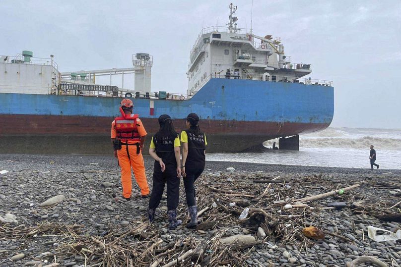 Beamte vor dem an Taiwans Küste gestrandete Frachtschiff, 26. Juli 2024.