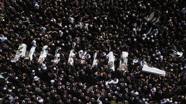 Mourners from the Druze minority surround the bodies of some of the youngsters killed in a rocket strike in the Israeli-controlled Golan Heights, July 28, 2024
