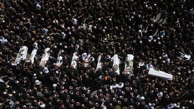 Mourners from the Druze minority surround the bodies of some of the youngsters killed in a rocket strike in the Israeli-controlled Golan Heights, July 28, 2024