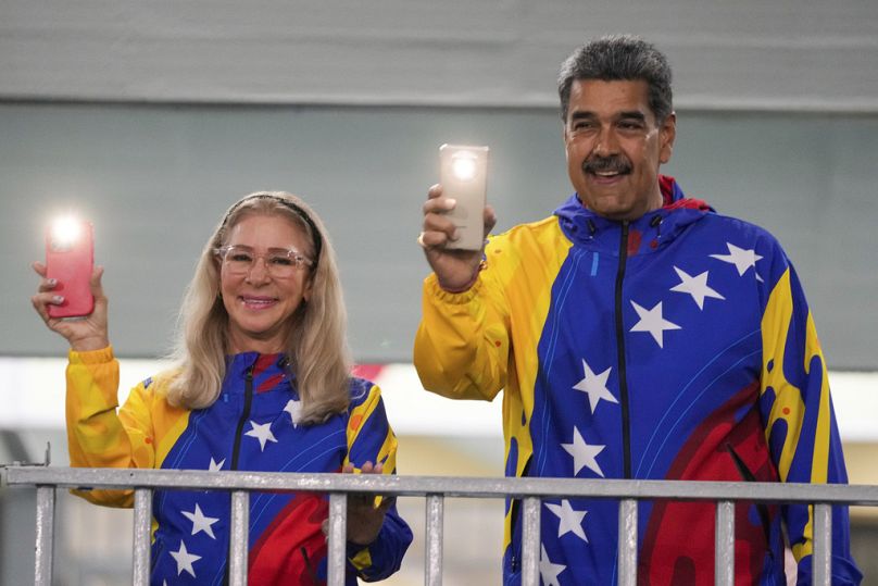 President Nicolas Maduro and First Lady Cilia Flores turn on their mobile phone flashlights after voting in the presidential elections in Caracas, Venezuela on Sunday