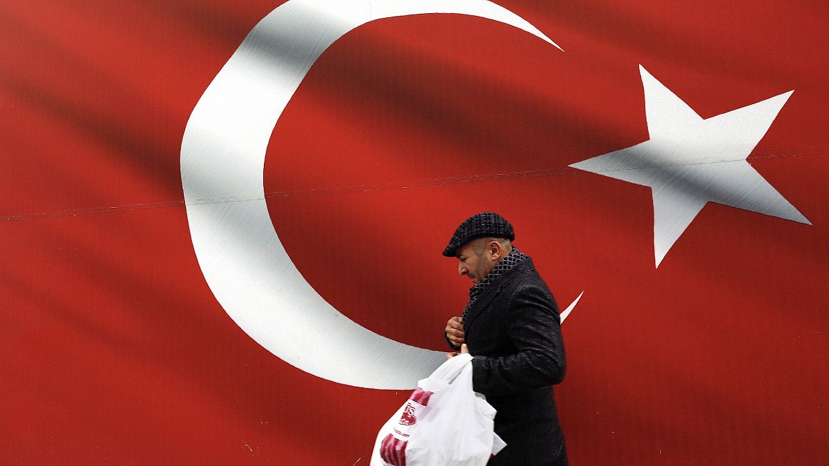 Bir adam, 31 Mart 2019 Pazar günü Ankara'da dev bir Türk bayrağının önünde yürürken görüntüleniyor. (Arşiv)