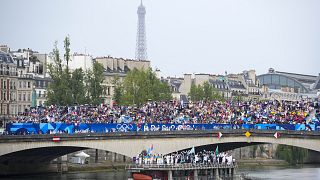 Atleti in barca lungo la Senna a Parigi, in Francia, durante la cerimonia di apertura dei Giochi Olimpici estivi del 2024, venerdì 26 luglio 2024.