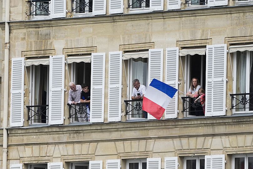 Los franceses se asoman a sus balcones antes de la ceremonia inaugural