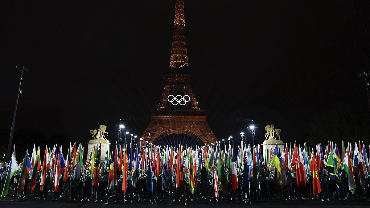 Katılımcı ülkelerin bayrakları, 26 Temmuz 2024 Cuma günü Fransa'nın Paris kentinde düzenlenen 2024 Yaz Olimpiyatları'nın açılış töreninde taşınıyor.