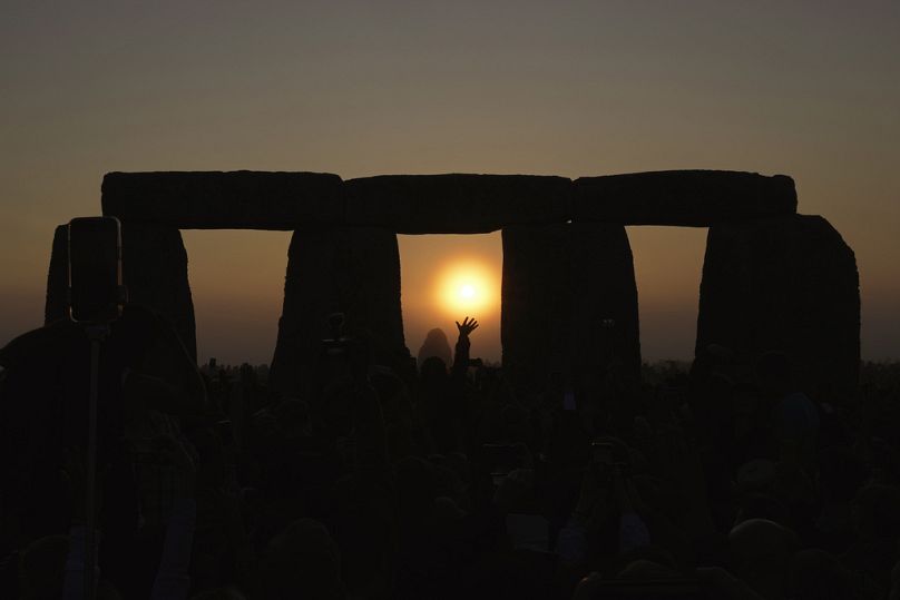 Pessoas reunidas no antigo círculo de pedra Stonehenge para celebrar o Solstício de verão, o dia mais longo do ano, perto de Salisbury, Inglaterra