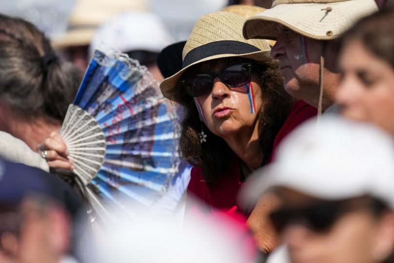 Ein Fan versucht, sich während der Ruderwettbewerbe bei den Olympischen Sommerspielen 2024 abzukühlen.