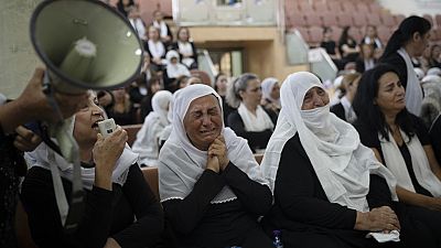 Des membres de la minorité druze assistent à une cérémonie à la mémoire des enfants et des adolescents tués lors d'un tir de roquette dans le village de Majdal Shams (AP Photo/Leo Correa).