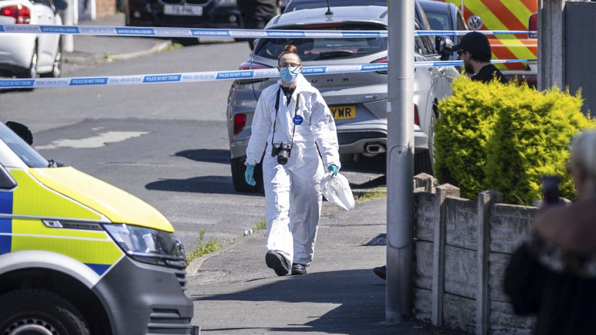 A police scenes of crime officer (SOCO) works at the scene in Southport, Merseyside