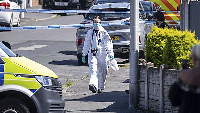 A police scenes of crime officer (SOCO) works at the scene in Southport, Merseyside