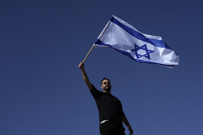 Ein Demonstrant schwenkt die israelische Nationalflagge zur Unterstützung von Soldaten, die wegen Misshandlung verhört werden, Montag, 29. Juli 2024. 