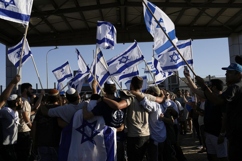 Demonstranten schwenken israelische Nationalflaggen zur Unterstützung von Soldaten, die wegen Misshandlung von Gefangenen verhört werden,  Montag, 29. Juli 2024. 