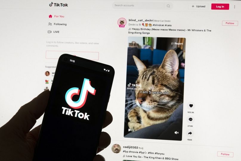 شعار TikTok على هاتف محمول أمام شاشة كمبيوتر في بوسطن