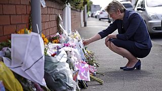 British Home Secretary Yvette Cooper looks at tributes near the scene in Hart Street where two children died and nine were injured in a knife attack.