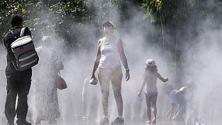 People refresh at a public water mist shower in the center of Paris, France, during the opening ceremony of the 2024 Summer Olympics, Tuesday, July 30, 2024.