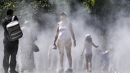 People refresh at a public water mist shower in the center of Paris, France, during the opening ceremony of the 2024 Summer Olympics, Tuesday, July 30, 2024.