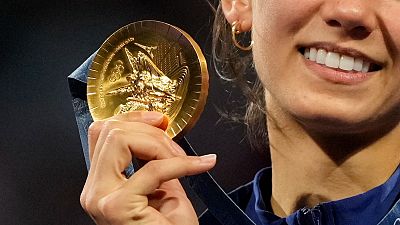 Um grande plano de uma medalha de ouro de Paris 2024 enquanto Lee Kiefer, da equipa dos EUA, celebra a vitória na competição individual feminina de florete 