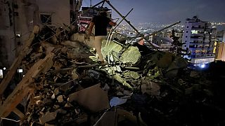 A man inspects a destroyed building that was hit by an Israeli airstrike in the southern suburbs of Beirut, Lebanon, Tuesday, July 30, 2024   (AP Photo/Hussein Malla)